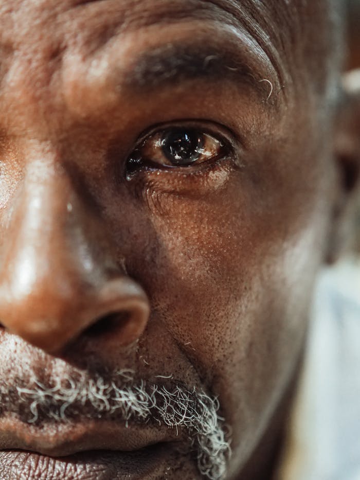 services-03 A close-up of an elderly man's face showing deep emotion and reflection.