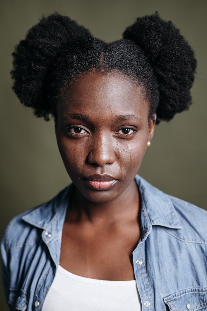 heros-img Close-up portrait of a woman with tears on her face, conveying emotion.